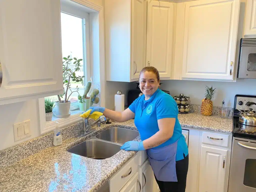 Touch of Europe employee cleaning homeowner's sink